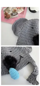 Detail of gray knitted koala hat featuring soft ear flaps and cute pom-pom animal eyes