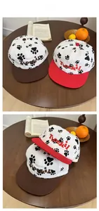 Detail of baseball cap showing contrast color brim and paw print pattern with embroidery