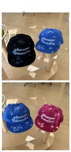 Detailed view of tie-dye graffiti embroidery on street style cotton baseball caps