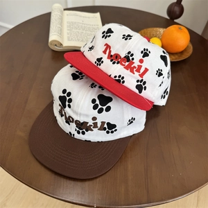 Cute puppy paw print baseball caps with Roeki embroidery on a wooden table