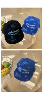 Detail of street style baseball caps with splash paint pattern and runners embroidery