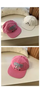 Close-up of pink and white baseball caps featuring dalmatian embroidery and authentic text
