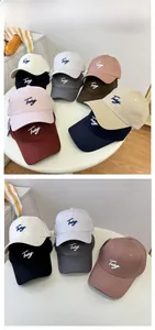 Detail showing various colors of embroidered cotton baseball caps with adjustable metal buckles