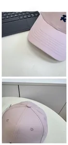 Detail of pink cotton baseball cap featuring blue NY embroidery and decorative brim stitching
