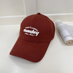 Casquette de baseball rouge foncé classique avec broderie blanche dans un studio épuré