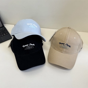 Retro embroidered baseball caps in light blue, black, and khaki on a white surface