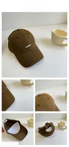 Detail view of brown cotton baseball cap showing embroidery and metal adjustment buckle