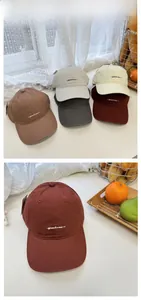 Detailed tile display and close-up of cotton baseball caps with letter embroidery