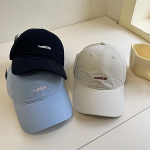 Three minimalist cotton baseball caps with nabitat embroidery in black, blue and beige
