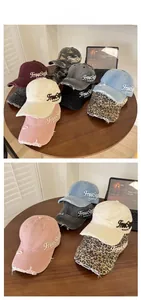 Detailed close-up of distressed washed denim baseball caps with FreeStyle embroidery