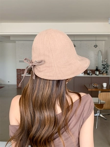Detail of light brown bucket hat with a stylish plaid bow on the back textile texture