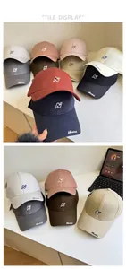 Détail de casquettes de baseball en coton multicolores avec logo N et visière courbée réglable