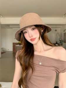 Detail of khaki bucket hat featuring brown checkered inner brim pattern on cotton fabric