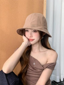 Close-up of a women's brown bucket hat with inner checkered pattern and wide brim detail