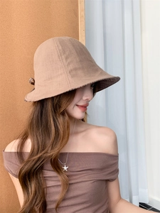 Detail of checkered bow and cotton-linen texture on khaki reversible sun hat