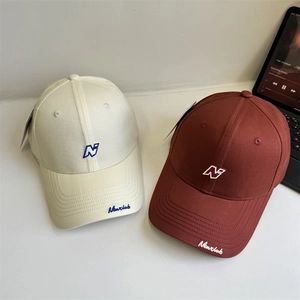 Classic baseball caps in beige and brown with N embroidery on minimalist white background
