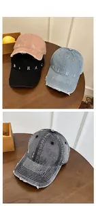 Detail view of washed denim baseball caps with MIRAC embroidery and distressed brim edge