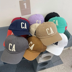 Multiple colorful cotton baseball caps with CA embroidery in a stacked display