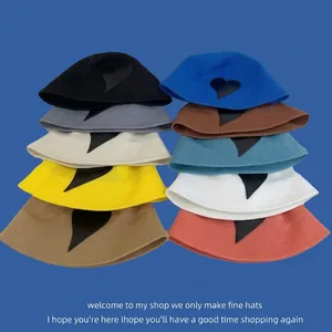 Selection of ten colorful knitted summer hats featuring chic black heart-shaped patches