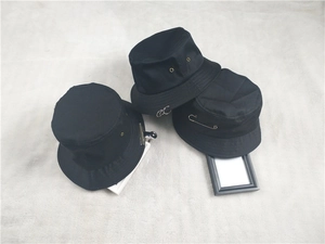 Détail de chapeaux bobs noirs en coton avec anneaux métalliques et épingles argentées