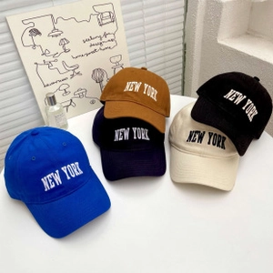 Top-down view of five solid cotton baseball caps with New York embroidery in varied colors