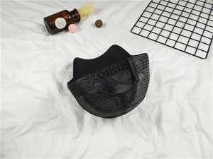 Detail of adjustable snapback closure and breathable mesh on a black baseball cap