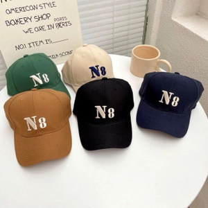 Flat lay of five cotton baseball caps with N8 embroidery on a minimalist white table