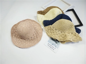 Vista dettagliata di quattro cappelli di paglia colorati con eleganti motivi traforati