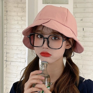 Detailed view of a soft pink wide-brim sun hat with natural wavy edges on a female model