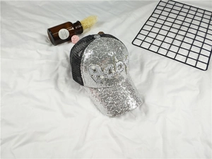 Detail view of the silver sequined mesh baseball cap with Baby pearl and rhinestone letters