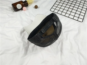 Detail of adjustable black mesh snapback cap with white sequin brim and plastic closure
