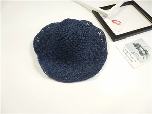 Dettaglio del cappello da sole lavorato a mano blu navy con motivo a trama traforata