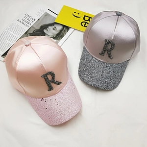 Detail of satin baseball hats with sparkling sequin brims and rhinestone R logo