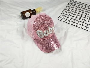 Detailed shot of pink sequin baseball cap with pearl Baby lettering and mesh back