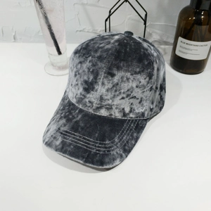 Dettaglio del cappello da baseball in velluto grigio che mostra trama e riflessi
