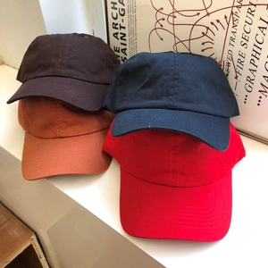 Dettaglio dei cappellini da baseball in cotone nei colori rosso blu marrone e arancio