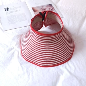 Detail view of red and white striped straw sun visor hat with woven texture