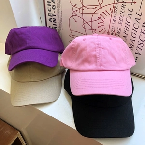 Berretti da baseball in cotone nei colori viola, kaki, rosa e nero su fondo bianco