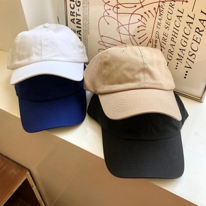 Vista dettagliata di quattro cappellini da baseball in cotone bianco, blu, kaki e nero