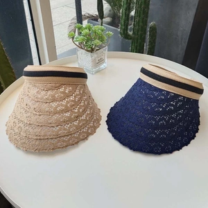 Detail of crochet straw open top visors in light tan and dark blue with elastic bands