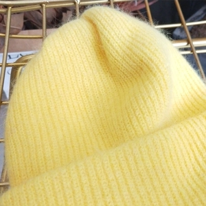 Detailed close-up of double-layered yellow Angora wool beanie with ribbed knit texture