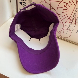 Dettaglio interno cappellino in cotone viola con etichetta di qualità e fodera
