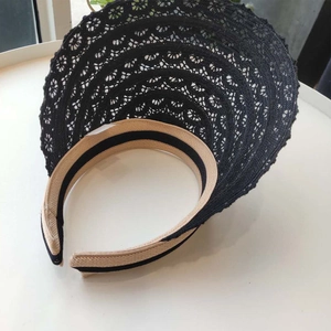 Close-up of sun visor with tiered black lace brim and striped fabric headband details