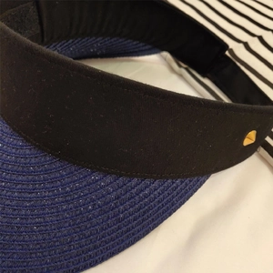 Detail of navy straw sun visor with gold metal stud and adjustable Velcro strap back