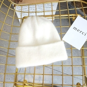 Close-up of white angora rabbit hair knit beanie with soft fluffy wool texture