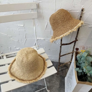 Handwoven straw sun hat with frayed edges for summer travel, available in beige and camel