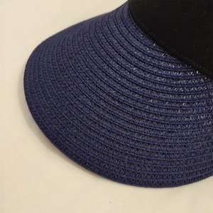 Detail of navy blue straw brim and black fabric stitching on foldable sun hat