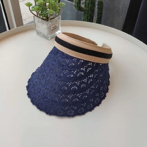 Detail of navy blue lace brim sun visor with khaki elastic band on a white table