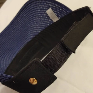 Detail of navy blue sun visor with adjustable velcro strap and golden metal stud decoration