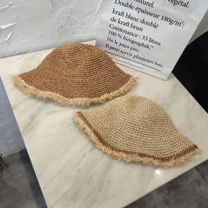 Detailed macro view of hand-woven straw hat fringe in caramel and oat beige colors